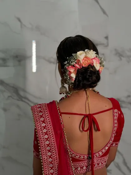 Another angle of this beautiful floral bridal bun, showing how the flowers are carefully placed to create a lush, elegant effect from every side.