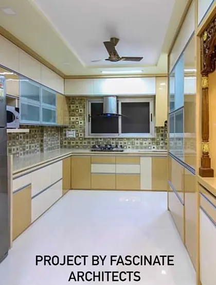 This spacious L-shaped kitchen in a Vashi row house combines beige and white cabinets for a warm, classic look. The design thoughtfully incorporates a dedicated pooja unit, blending spiritual and functional spaces.