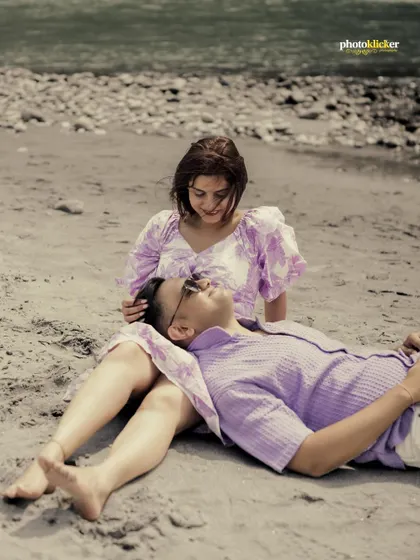 A peaceful and intimate shot of the groom resting his head in his bride's lap as they relax on the beach.