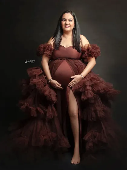 This glowing mama looks so confident and beautiful in a dramatic brown ruffled gown. A simple, dark background really makes her and the stunning outfit shine.