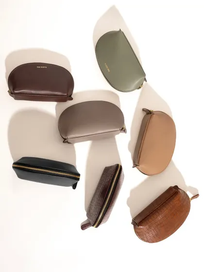 A creative flat-lay of multiple half-moon pouches in various colors. The play with light and shadow adds depth and artistry to what could be a simple product lineup, making it more engaging for a catalogue.
