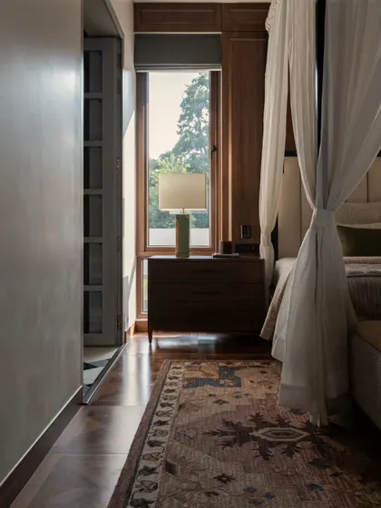 The play of light and shadow in the master bedroom at Pràna. The rich walnut wood floors and furniture ground the space, while the light fabrics keep it feeling airy.