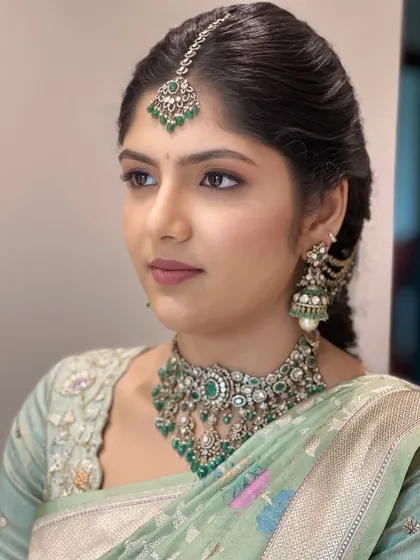A close-up profile, highlighting the beautiful jhumkas and the soft, defined eye makeup that completes this elegant look.
