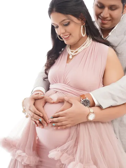 A close-up shot capturing the love between the couple as they form a heart with their hands on the baby bump. It's a classic and sweet pose for any maternity session.