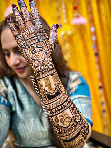 A side view of the Krishna-themed bridal mehndi, highlighting the intricate details and figures that wrap around the arm.
