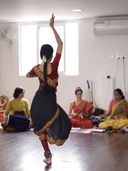 A student performs during our Vijayadashami event, with others observing. The studio serves as an intimate performance space for students to showcase their progress.
