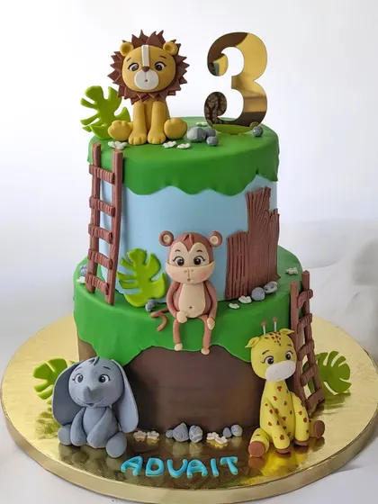 This two-tier jungle animal cake is full of fun details, like a monkey sitting on a branch and a cute elephant at the base. It's perfect for a 3rd birthday.