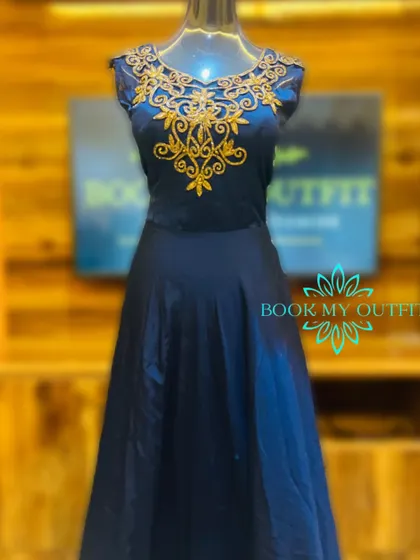 This classic navy blue A-line gown features beautiful gold embroidery around the illusion neckline. It's a timeless and sophisticated option for a wedding guest or for attending a formal reception.