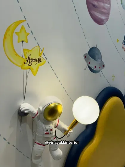 Detail of the astronaut wall lamp, which holds a glowing moon. It's these small, imaginative details that bring a themed room to life and make it a cherished space for a child.