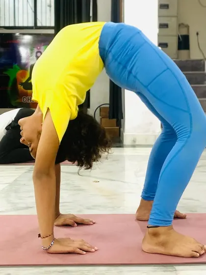 Urdhva Dhanurasana (Wheel Pose) is an energizing backbend that opens the chest and shoulders. It builds strength and confidence, helping to counteract the slouched posture from sitting at a desk.