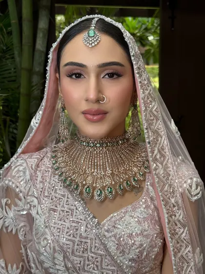 A portrait capturing her serene beauty. The airbrush makeup ensures a flawless, long-lasting finish, which is essential for an outdoor wedding.