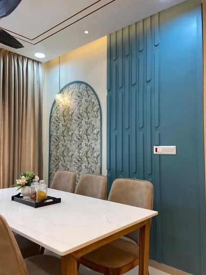 A closer look at the wall decor in the dining room. The combination of the leaf-patterned wallpaper within the arch and the fluted teal panel creates a rich, layered look.
