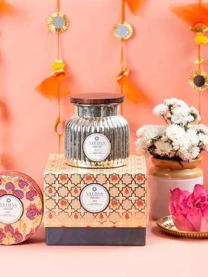 A festive display of our candles, including the popular Persian Oud in a mercury jar and a decorative tin. These pieces are designed to be a beautiful part of your festive home decor.