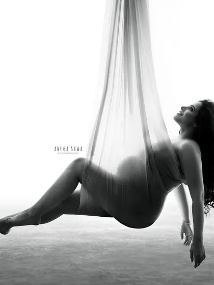 A creative and unique aerial shot. Suspended in soft fabric, this black and white image is a true work of art, symbolizing the feeling of being lifted and transformed by motherhood.