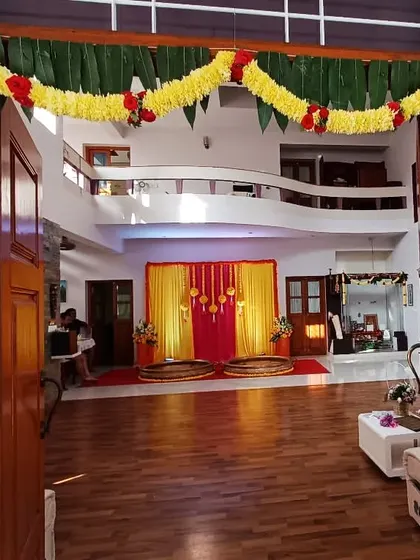 A traditional welcome for a home-based ceremony. The main door is decorated with thick garlands of marigold, mango leaves, and other flowers, setting a festive tone right from the entrance.