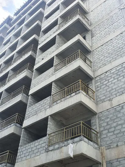 A duplicate close-up of the balconies under construction, showing the raw concrete and rebar details.
