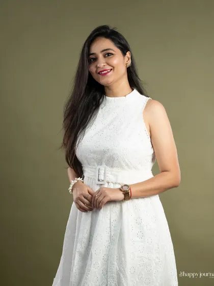 A friendly and warm professional portrait. The soft smile and relaxed posture make the subject appear open and engaging, which is ideal for professionals in client-facing roles. The simple green background adds a touch of color without being distracting.