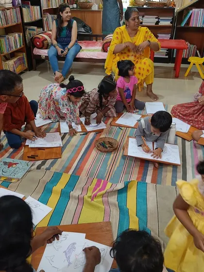 A closer look at the children engrossed in their drawings. We provide wooden lap boards to make it easy and comfortable for them to create their art on the floor.