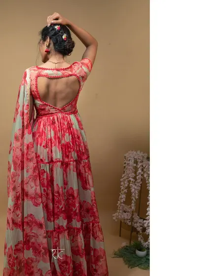 The back of the red floral gown features a charming heart-shaped cutout, adding a playful and romantic detail to the elegant design.