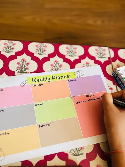 Writing down plans on the reusable weekly planner. The surface is smooth and easy to write on.