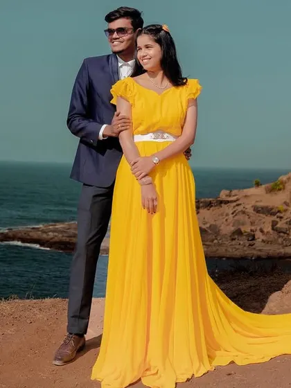 Sunshine and sea breeze. This bright yellow trail gown is a cheerful and beautiful choice for a beachside pre-wedding shoot, adding a pop of color to the landscape.