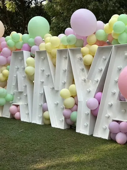 Large marquee letters spelling out the birthday girl's name, "RANYA," nestled in a sea of pastel balloons.