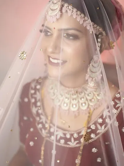 A bride's portrait is more than just a photo; it's a reflection of her journey. This shot, with the veil gently framing her smile, captures the anticipation and quiet joy of the wedding day in a timeless and emotional way.