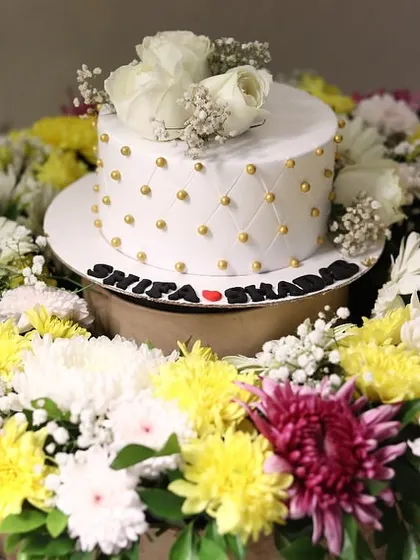 We love making celebrations extra special with our floral platters. Here, we created a vibrant ring of fresh yellow, white, and purple chrysanthemums to frame an elegant white cake for a Nikah ceremony, with the couple's names displayed at the base.