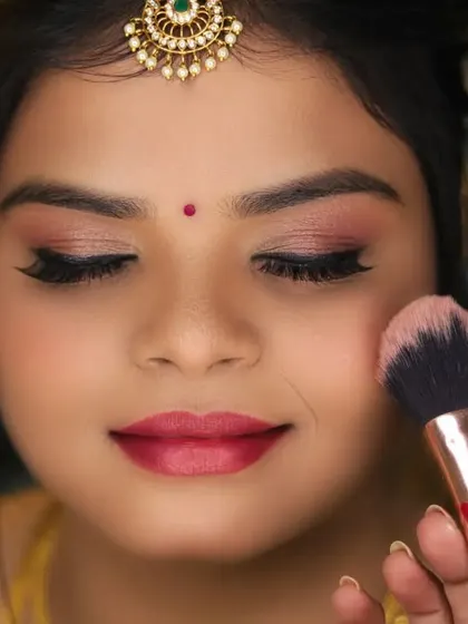 A close-up of the makeup artist applying blush, a key part of the bridal transformation.
