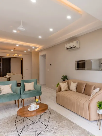 A contemporary living room design featuring a mix of seating options in soft pastel tones. The geometric coffee table and minimalist decor create a clean, uncluttered look, perfect for modern apartment living.