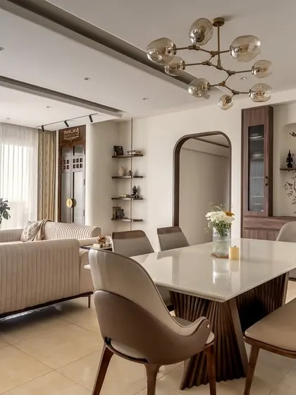 The dining area continues the living room's soft, muted tones for a seamless feel. I used a combination of chairs and a bench for relaxed seating, anchored by a simple wall cabinet and soulful artwork.