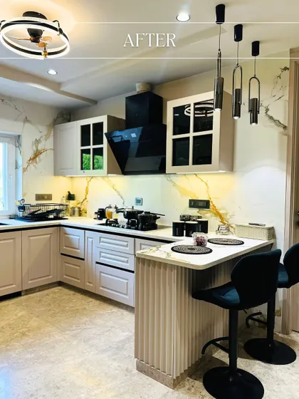 A stunning kitchen transformation, now featuring elegant off-white cabinetry, a dramatic black range hood, and a beautiful marble backsplash with gold veining.