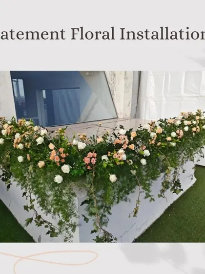 This post on "Statement Floral Installations" features a lush arrangement of greenery and pastel roses cascading over a counter, perfect for making a grand entrance.