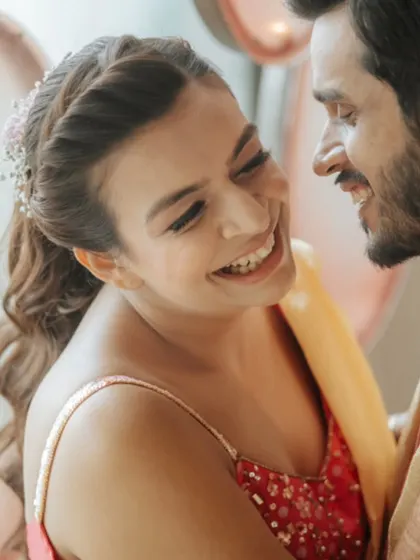 A close-up shot capturing the genuine laughter and connection between Karan and Vrinda during their pre-wedding festivities.
