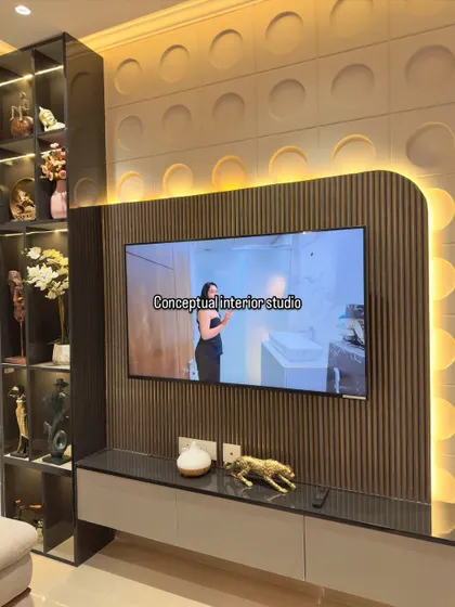 This TV unit combines a fluted panel, a textured 3D background, and a vertical display case. The backlighting creates a warm ambiance and highlights the different textures.