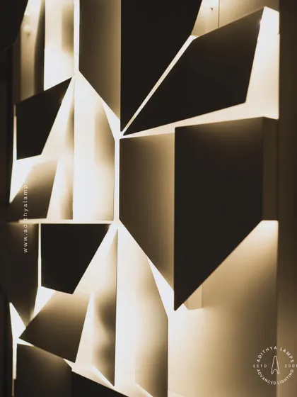 This 3D geometric wall light plays with light and shadow. The puzzle-like arrangement of white panels creates pockets of light, turning a simple wall into a dynamic feature. It is a perfect piece of illuminated wall art.