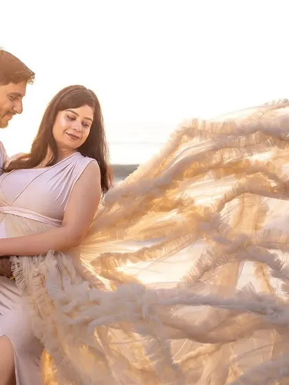 The sunlight filtering through the transparent fabric of the gown creates a magical, ethereal effect in this couple's portrait.