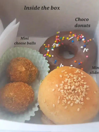Our kids' party boxes are always a hit. This one is packed with treats little ones love: mini sliders with fresh patties, crispy cheese balls, and a chocolate donut with sprinkles. It makes party food fun and hassle-free for parents.