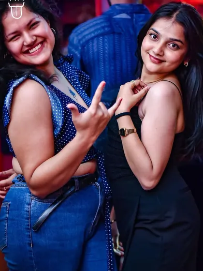 Friends making the rock-on sign, fully embracing the party spirit.