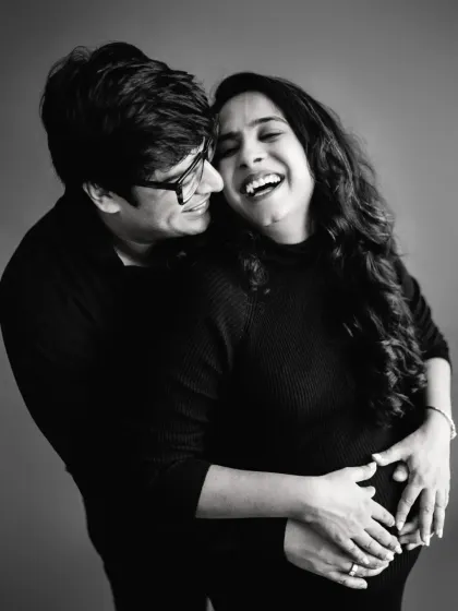 Pure laughter and joy between the couple in this candid black and white shot. These unposed moments are often the most cherished, capturing the real connection and happiness of expecting a child together.