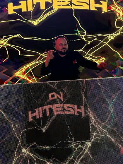 Pointing at the camera from my custom-branded DJ booth. The visuals extend from the main screen right down to the console itself for a cohesive look.