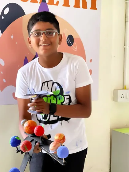 This student is thrilled to show off both his solar system and fighter jet models, two popular projects from our summer camp.