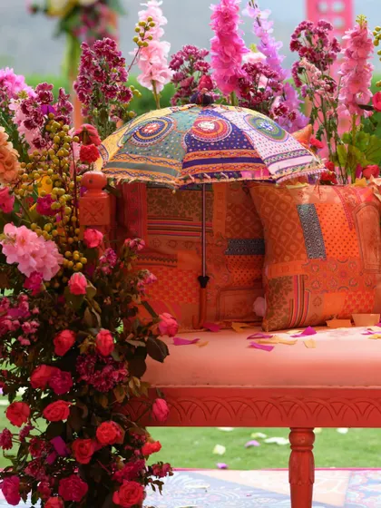A beautiful seating detail from Taapsee's Haldi, with a colorful patchwork umbrella and cushions adding a bohemian touch.