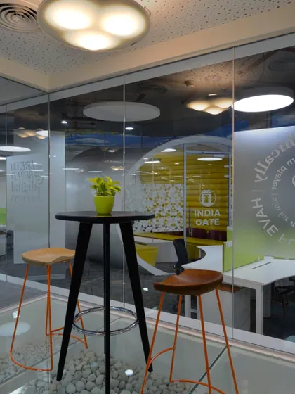 Why do interview rooms need to be formal? This informal meeting space features bar stools and a high table, with a glass wall that looks out onto the office.