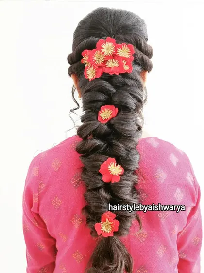 A beautiful and voluminous messy braid. I added red floral clips throughout the braid to add a pop of color and texture, making it perfect for a festive occasion.