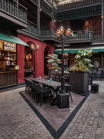 This seating area at Street 1522 is defined by large planters containing leafy foliage. This approach helps create intimate zones within a large open courtyard, offering guests a sense of privacy while still being part of the vibrant atmosphere.
