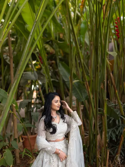 A beautiful solo portrait of the bride-to-be at her engagement, set against a lush green backdrop.