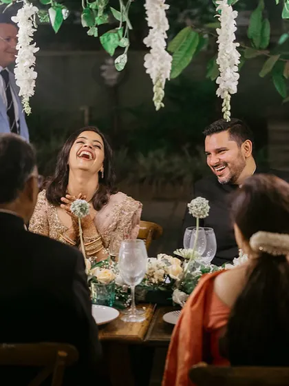 A moment of pure laughter and joy at an intimate wedding dinner. Our goal is to create spaces where families and friends can connect and create memories like this.