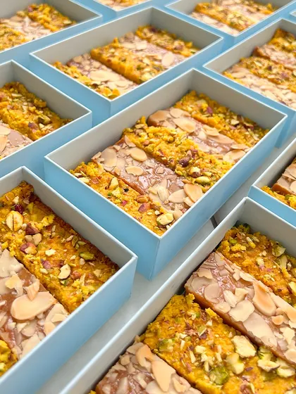 Announcing your little miracle? Our artisanal bulk gifts, like these boxes filled with assorted nut and saffron bars, are a delightful way to spread the love.
