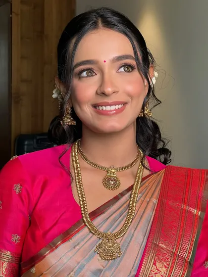 A joyful, upward glance from Soumita. Her makeup is light and radiant, perfect for a traditional South Indian wedding ceremony.